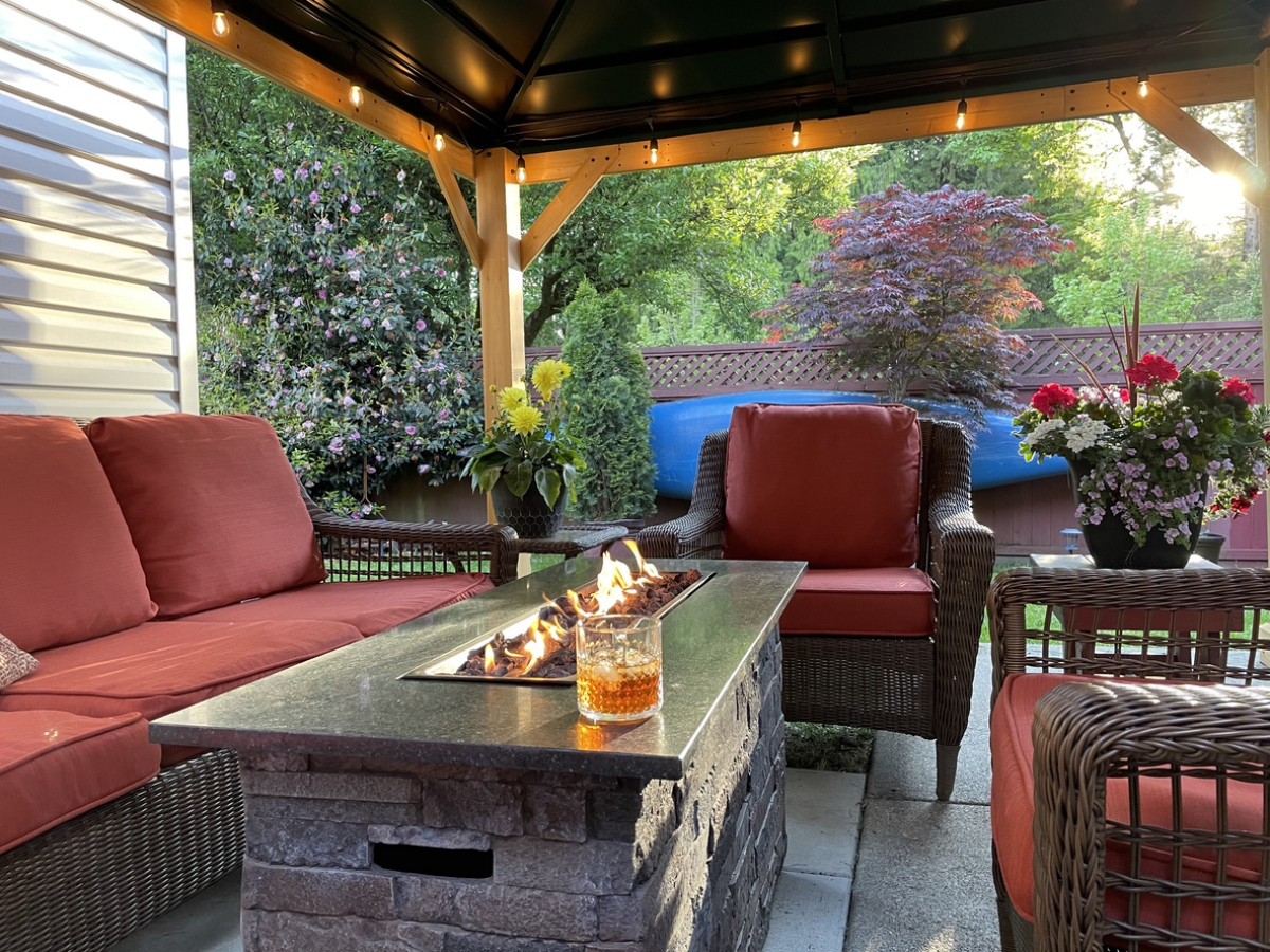 Feuertisch auf der überdachten Terrasse und bequeme Outdoor-Sitzmöbel 
