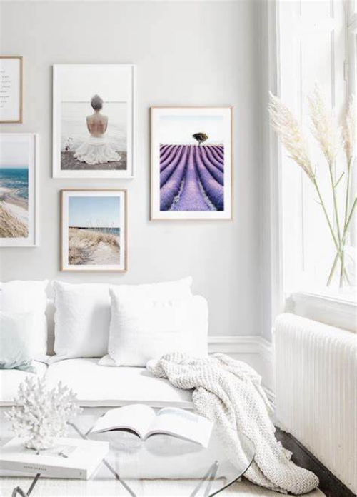 ein Wohnzimmer in Weiß gestaltet mit schönen Wandbildern dekoriert