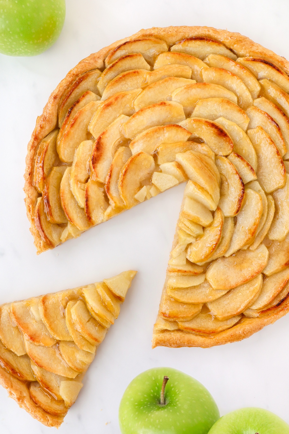 runder Apfelkuchen mit Apfelscheiben darauf
