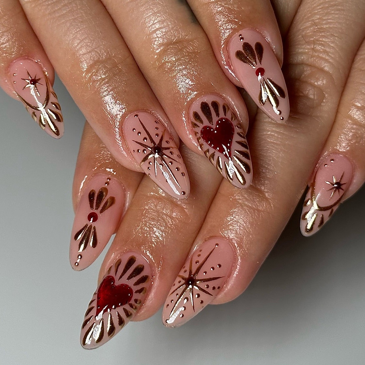 lange Nägel in Rosa und Dunkelrot mit glitzernden Ornamenten 