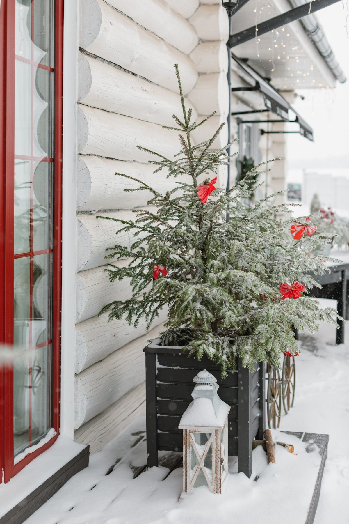 Tannenbaum und Laterne vor dem Haus im Schnee