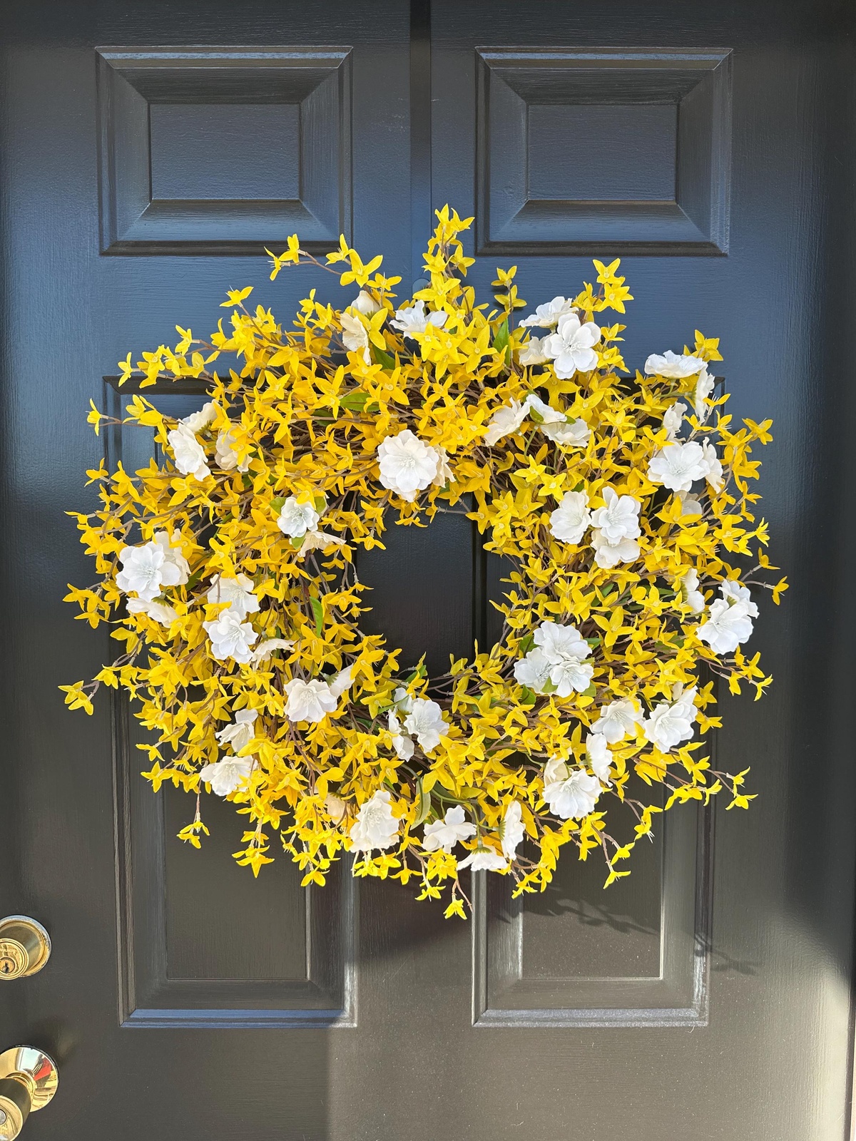 visueller Kontrast - goldgelber Kranz an schwarzer Haustür