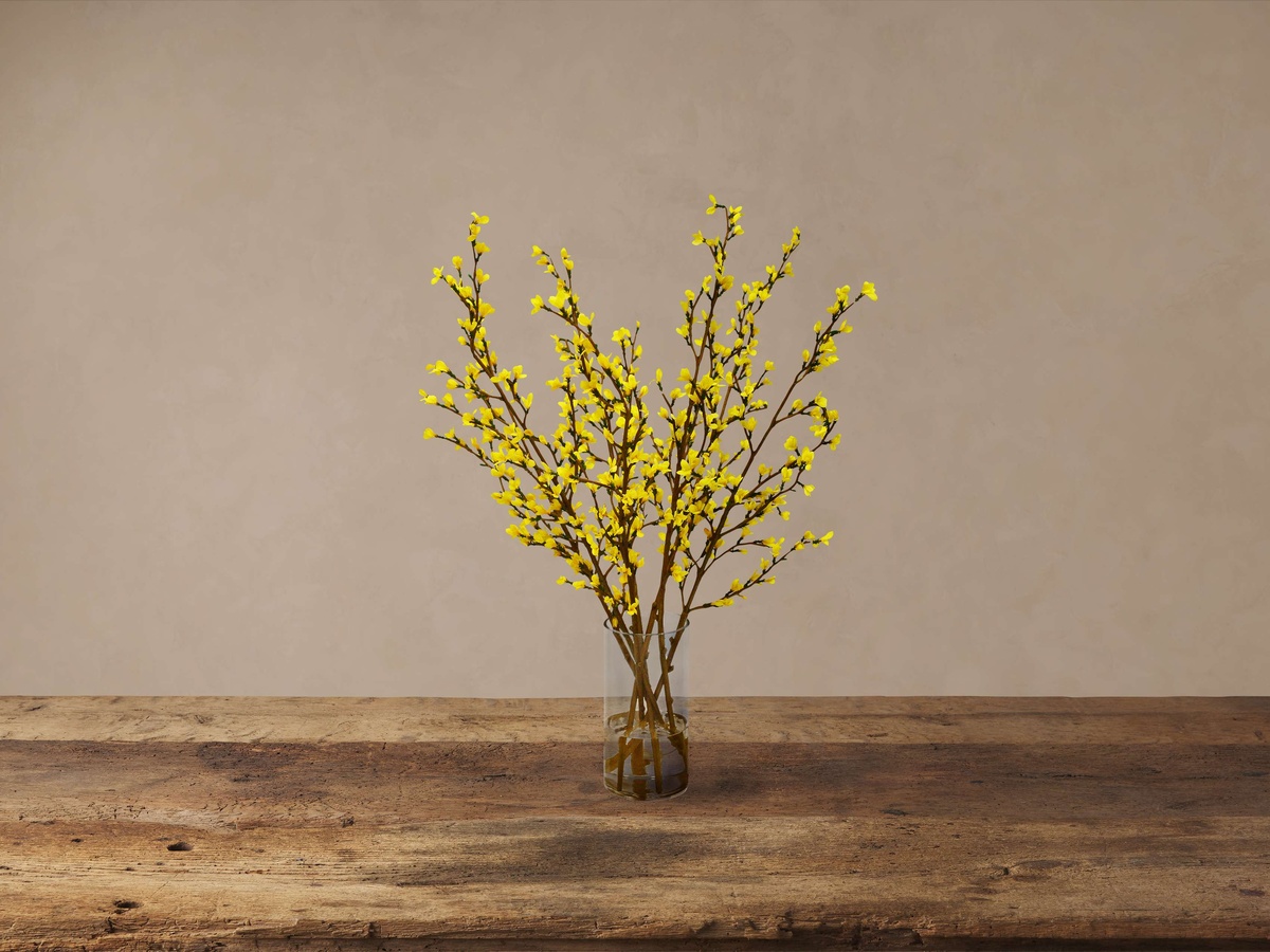 gelb blühende Zweige in einer kleinen Glasvase