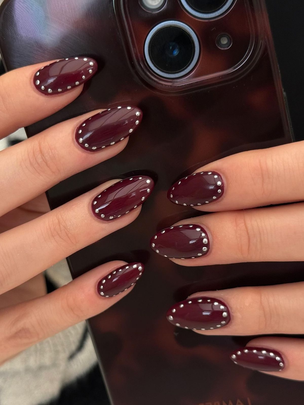festliche weinrote Maniküre mit silbernen Pünktchen